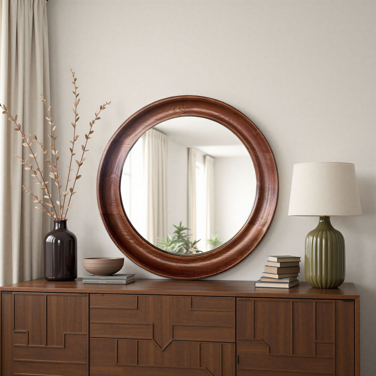 Round wooden mirror on a wooden dresser with decorative items.