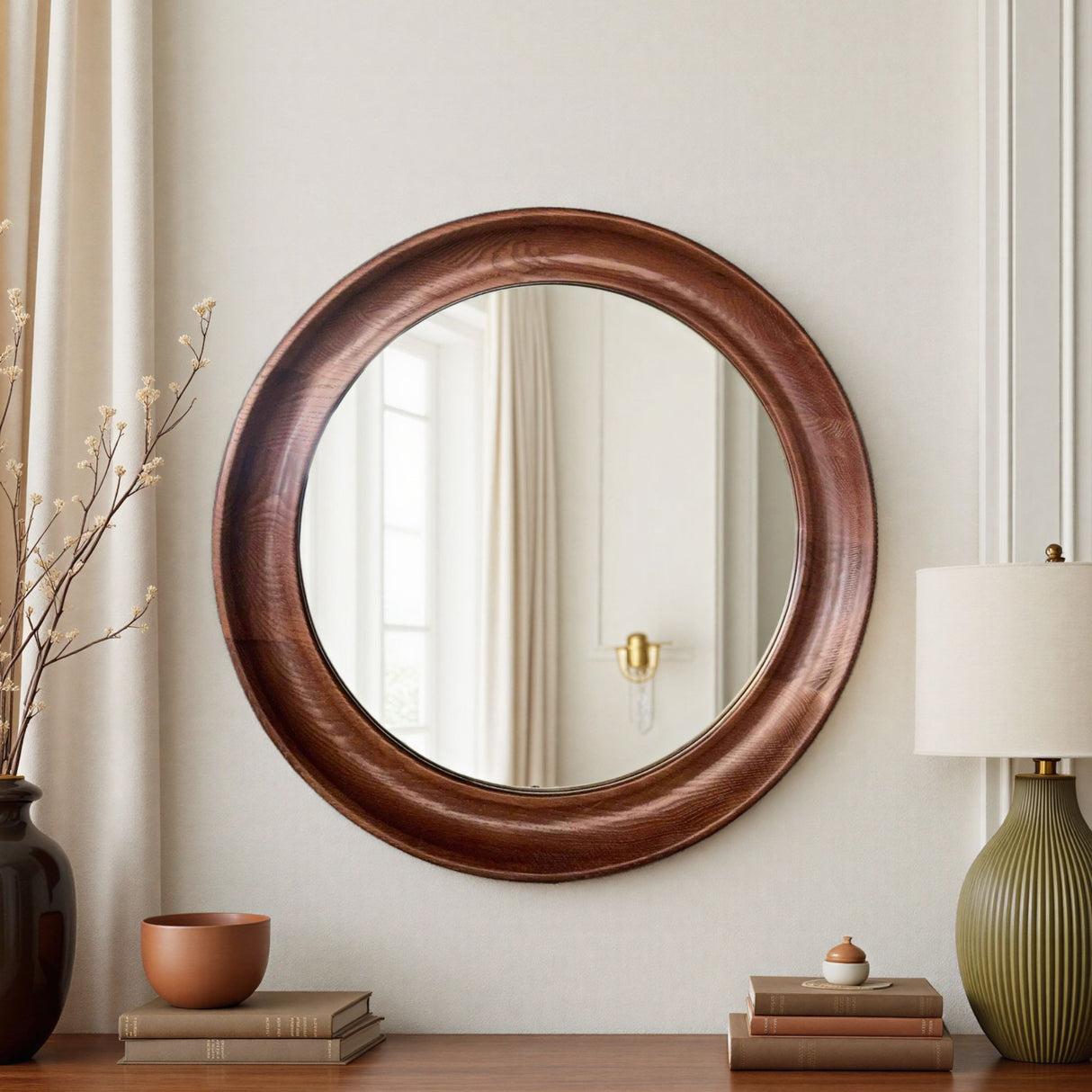 Round wooden mirror on a wall with decorative items below