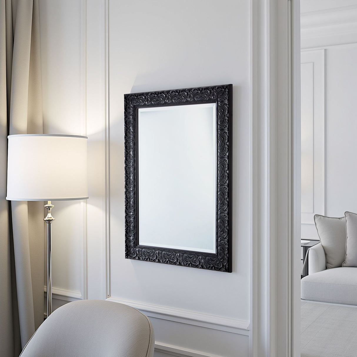 Decorative black-framed mirror on a wall with a lamp and sofa in the background