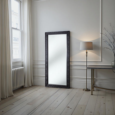 Modern interior with a large mirror, lamp, and table against a white wall.