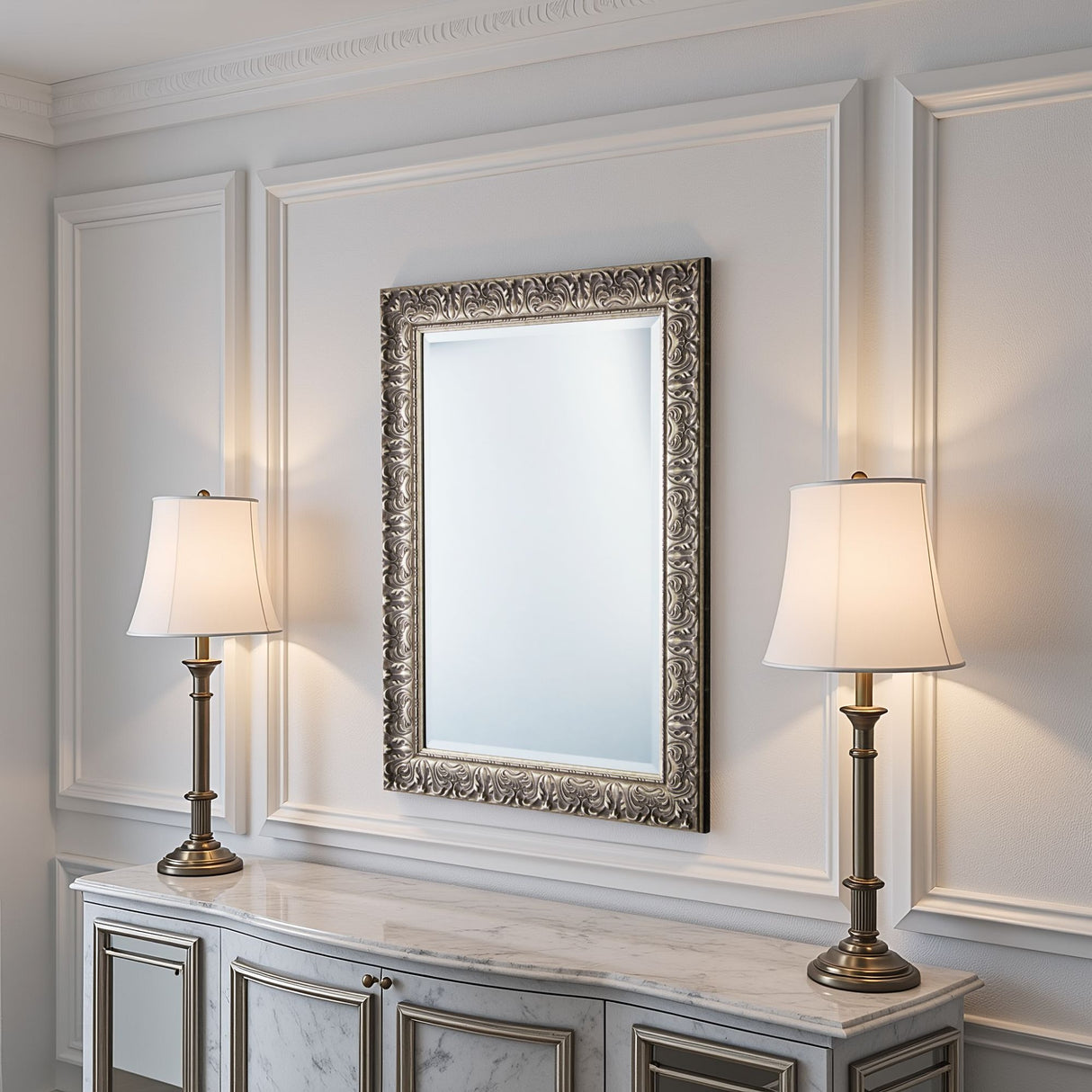Decorative mirror with ornate frame between two lamps on a marble surface.