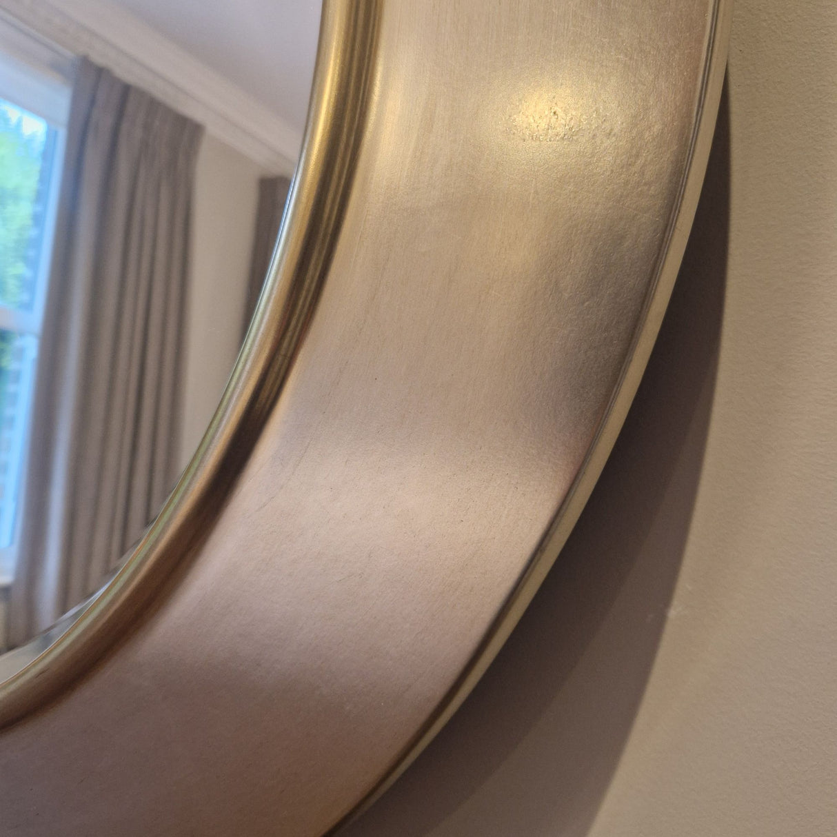 Round gold-framed mirror on a wall