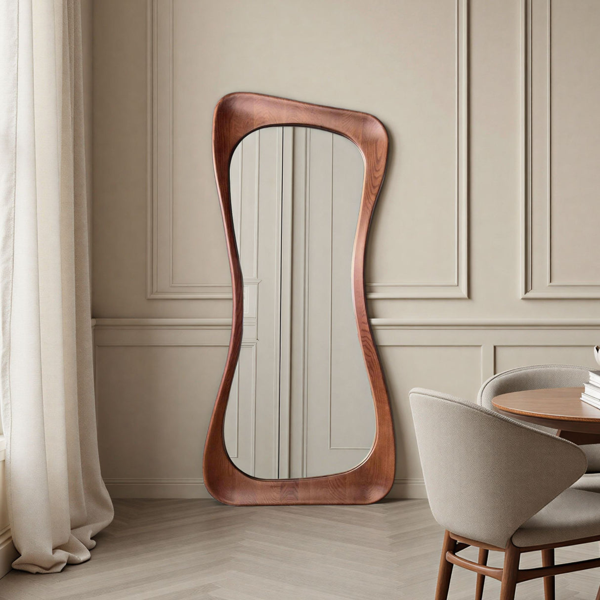 Wooden floor mirror with wavy design in a room with beige walls and a dining table.