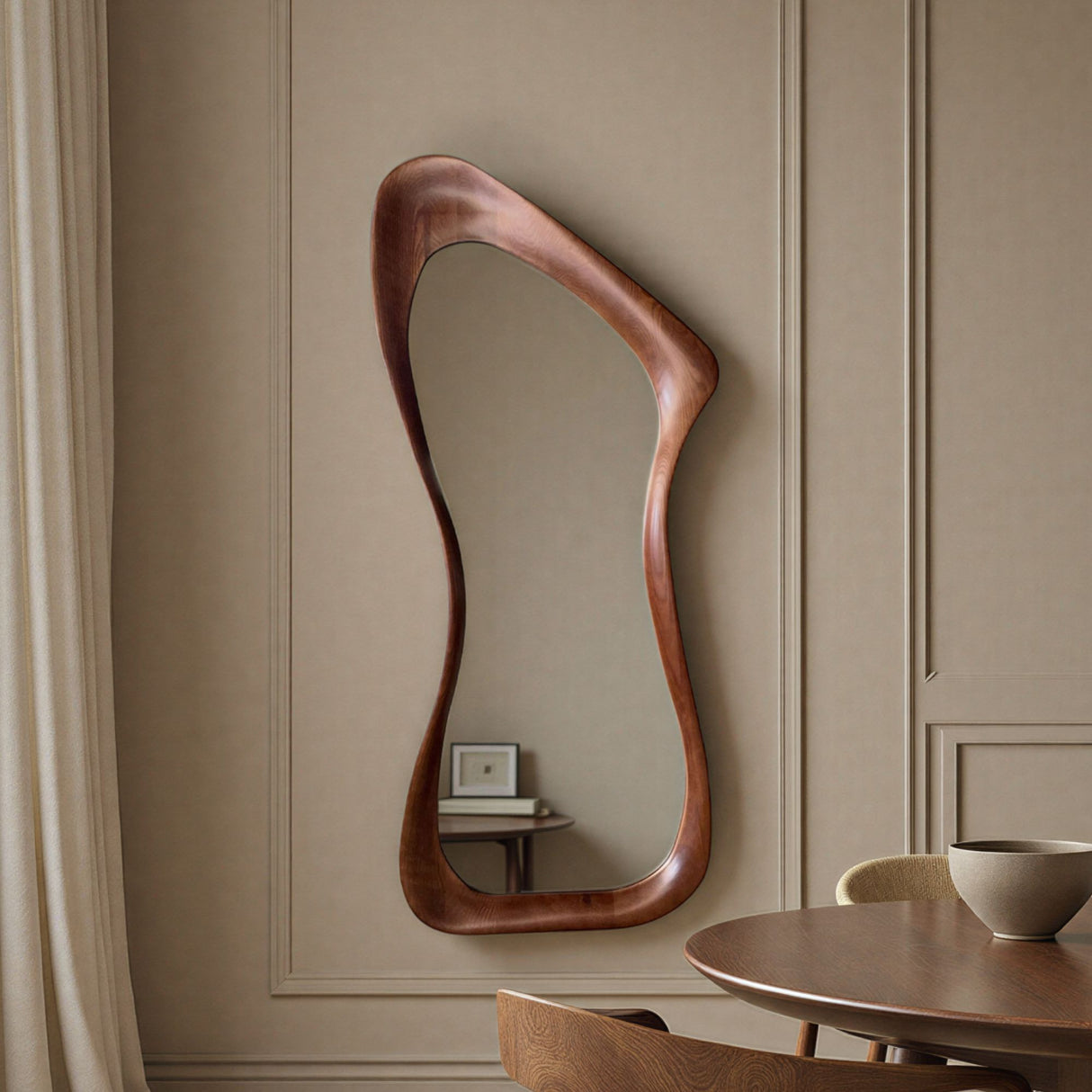 Wooden wall mirror with wavy design on a beige paneled wall.