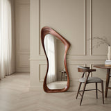 Wooden floor mirror in a stylish room with a chair and table.