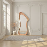 Modern floor mirror with a unique wooden frame in a stylish room with light-colored walls and wooden floor.