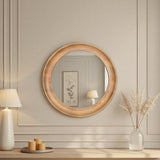 Round wooden mirror on a wall with decorative items below.