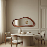 Dining room with a round table, chairs, and a large mirror on the wall.