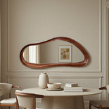 Elegant dining room with a unique wooden mirror on the wall, round table, and chairs.