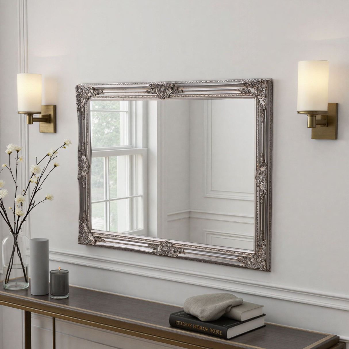 Decorative mirror with ornate frame on a wall above a console table.