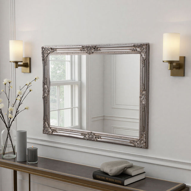 Decorative mirror with ornate frame on a wall above a console table.