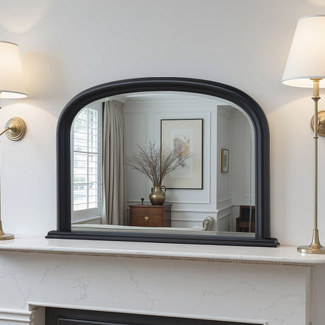 Decorative mirror with black frame on a white wall above a fireplace.