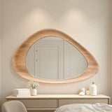 Wooden mirror on a wall above a dresser with decorative items.