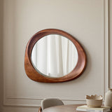 Round wooden mirror on a wall with a neutral background