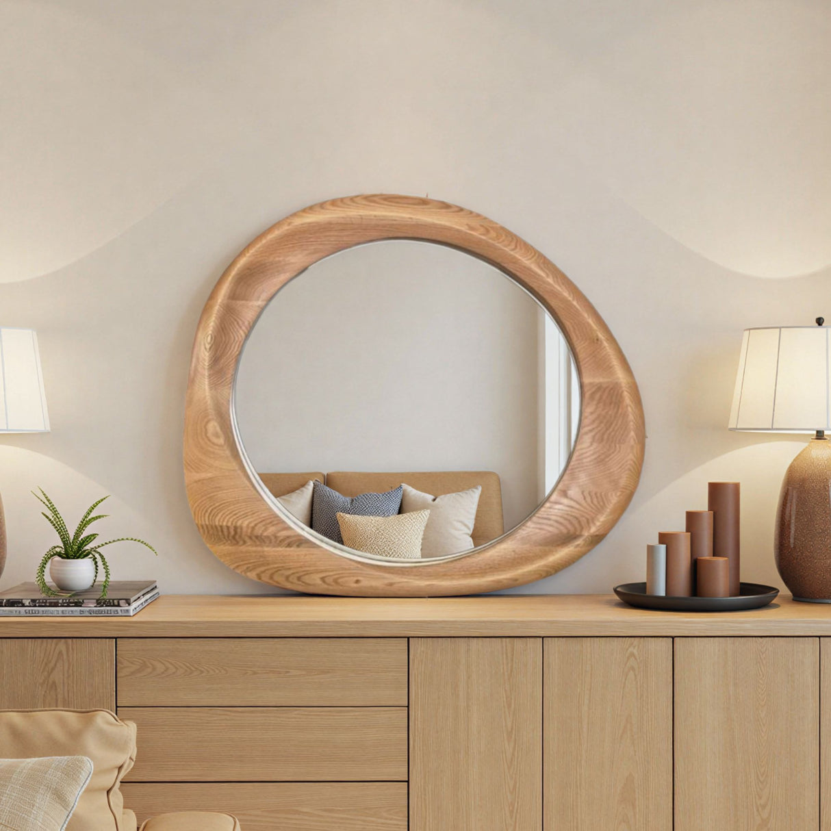 Round wooden mirror on a wooden dresser with decor items in a room.