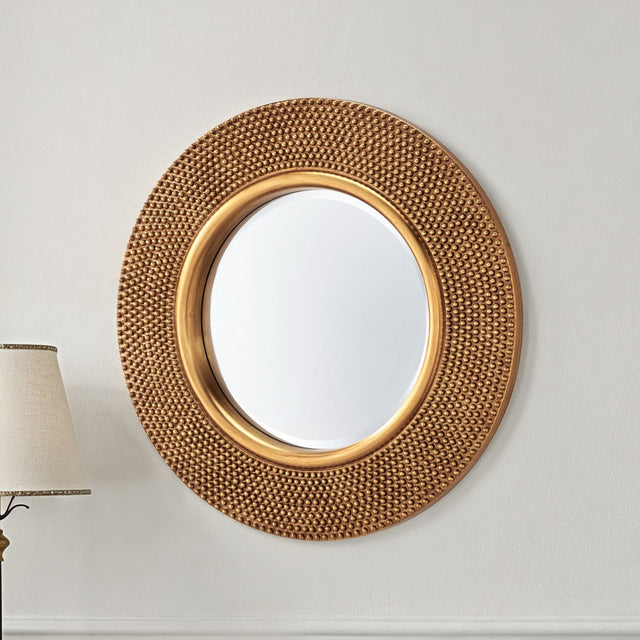 Decorative gold mirror on a white wall with a lamp in the corner.