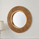 Decorative gold mirror on a white wall with a lamp in the corner.