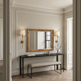 Decorative mirror with gold frame on a wall in a stylish interior setting.