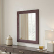 Wooden mirror with decorative items on a dresser against a neutral wall