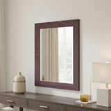 Wooden mirror with decorative items on a dresser against a neutral wall