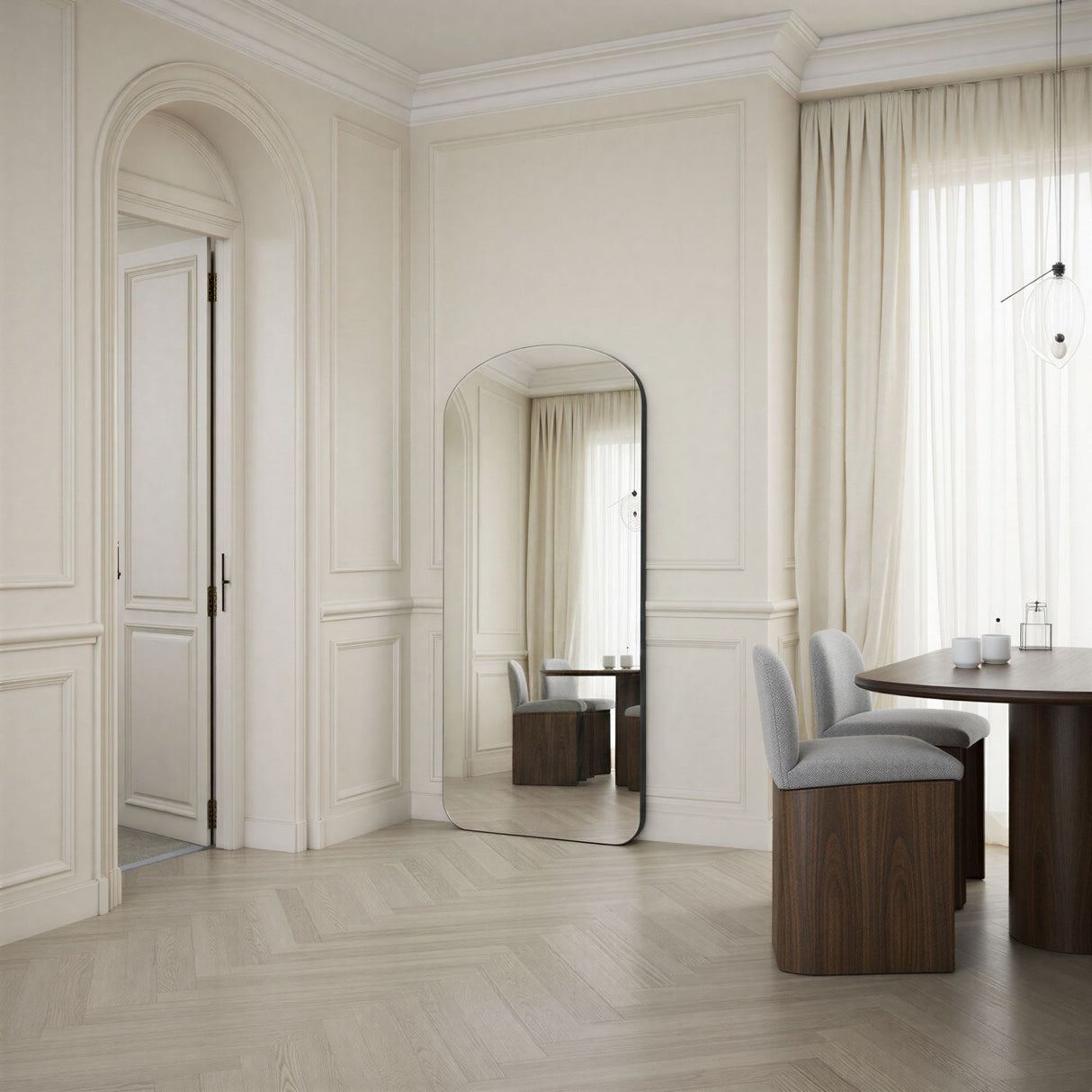 Modern interior design with a mirror, table, and chairs in a well-lit room.