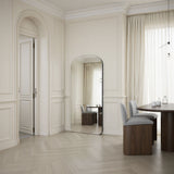 Modern interior design with a mirror, table, and chairs in a well-lit room.