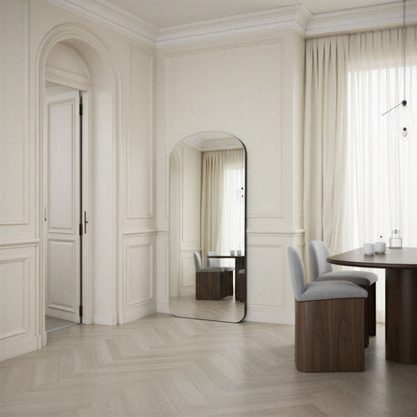 Modern interior design with a mirror, table, and chairs in a well-lit room.
