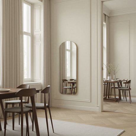 Dining room with wooden table, chairs, and a large mirror on the wall.