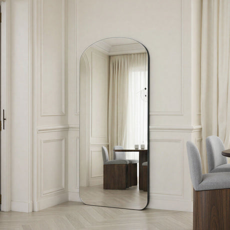 Large floor mirror in a room with white walls and furniture.