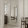 Modern interior with a standing mirror, furniture, and decor elements.