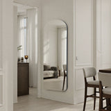 Modern interior with a standing mirror, furniture, and decor elements.