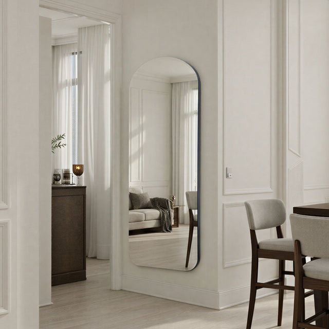 Modern interior with a standing mirror, furniture, and decor elements.